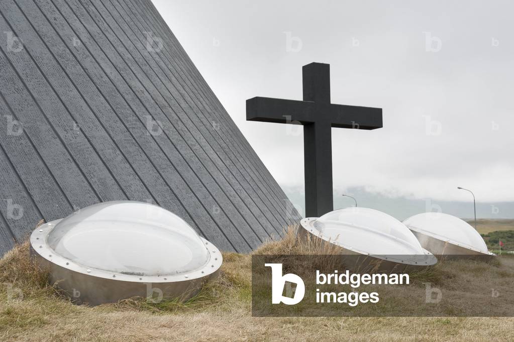 Modern concrete church with a large cross and round windows; Bloenduos; Iceland; Scandinavia; Northern Europe; Europe