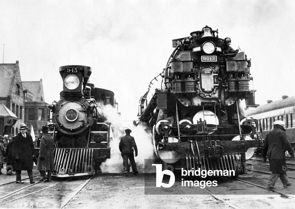 Two trains with steam locomotives in a railway station.