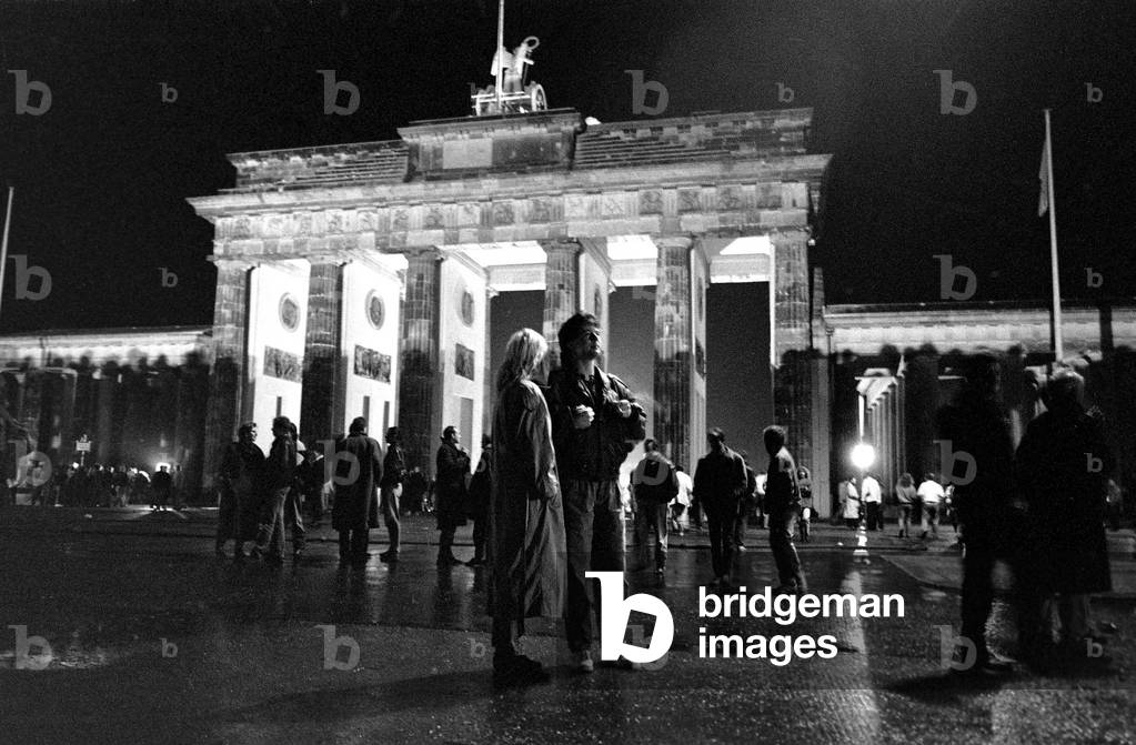 Passers-by at the Brandenburg Gate gaze upon the Berlin Wall, November, 1989 (b/w photo)