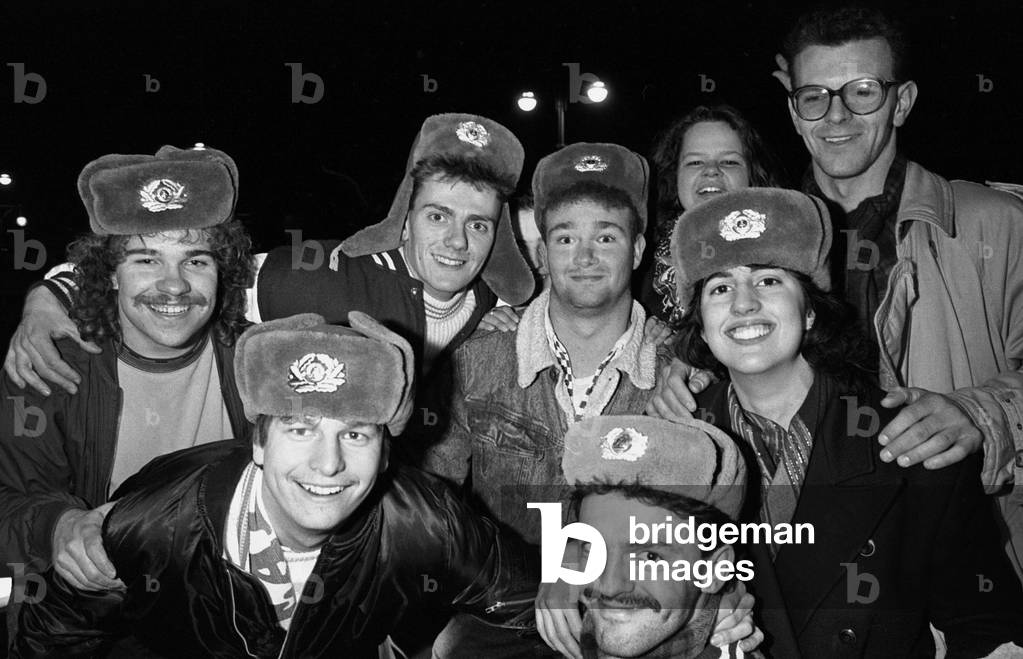 Citizens celebrate the fall of the wall with the NVA fur hat on their head, Berlin on 11 November, 1989 (b/w photo)