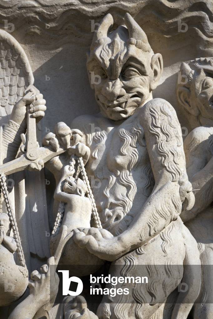 Detail of the scene of the weighing of souls to the eardrum of the portal of the Cathedrale Notre-Dame de Paris. A huge hairy devil wears on the flower of the scales to try to take the soul to Hell. This scene was restored by Geoffroy-Dechaume in 1851 Cathedrale Notre Dame de Paris - Paris 4 - XIIIeme, XIIIeme, XIXeme, rehabilitation by Viollet-le-Duc -