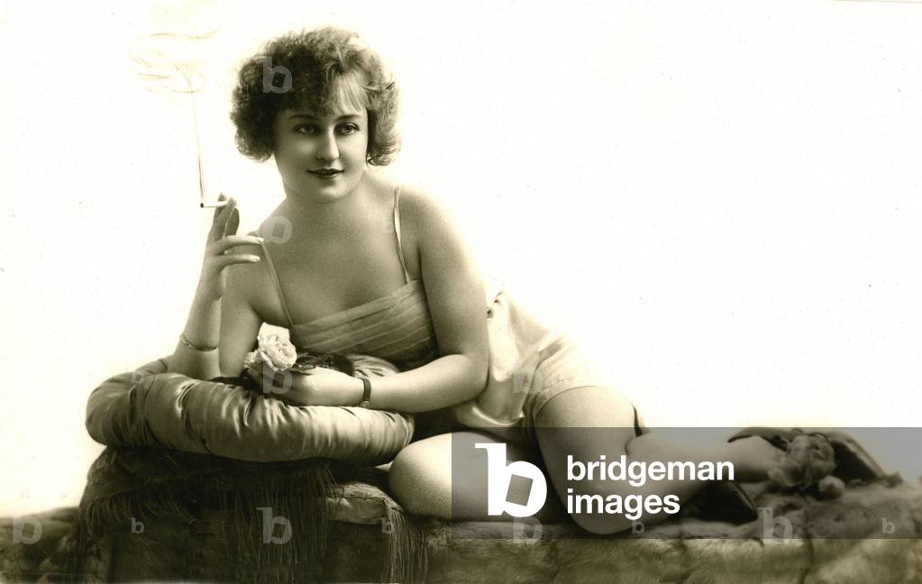 Postcard with young woman in intimate lingerie smoking a cigarette 1920