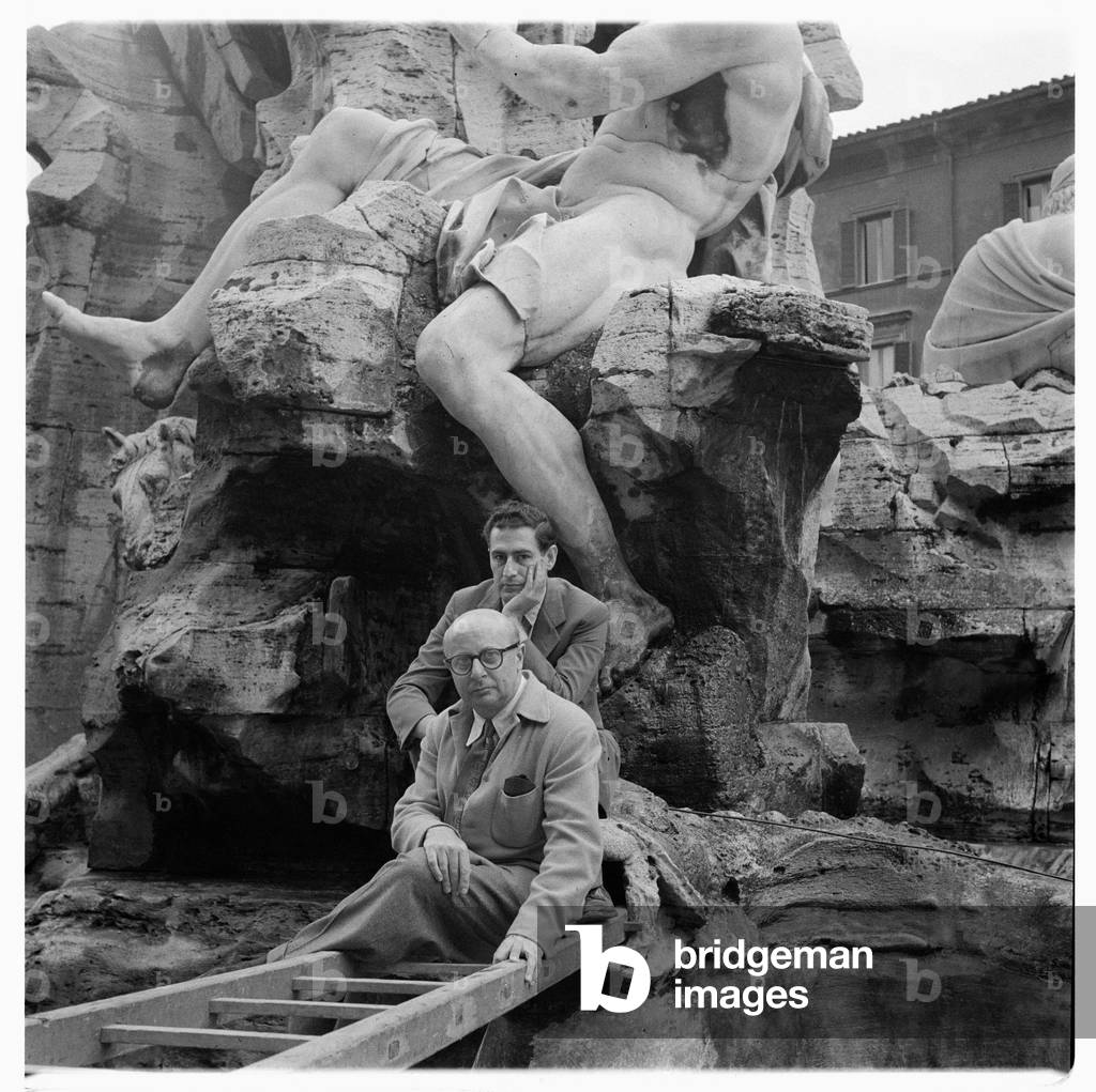 Portrait of two unknown men standing in front of the Fountain of the Four Rivers, Fontana dei Quattro Fiumi, Rome, Italy, early early 1950's