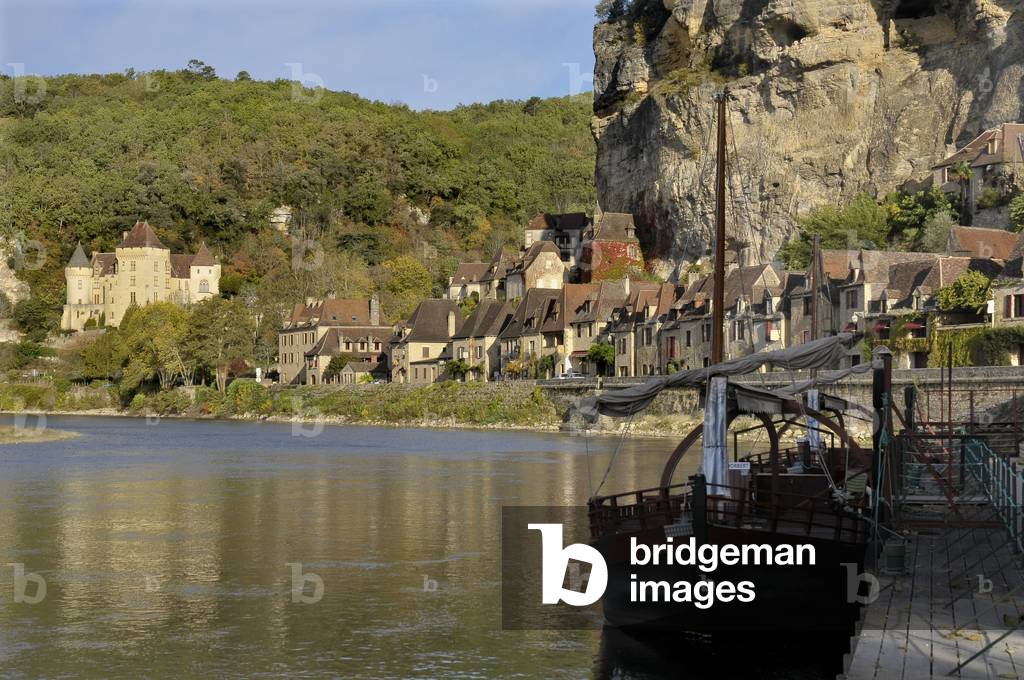La Roque-Gageac, seen from the Dordogne. A Gabare in the foreground. Troglodyte village