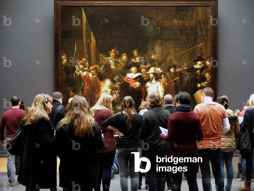 Rijksmuseum, Amsterdam: the public in front of the painting “The company of Frans Banning Cocq and Willem van Ruytenburch called “The Night Watch”” - Author Rembrandt 1642