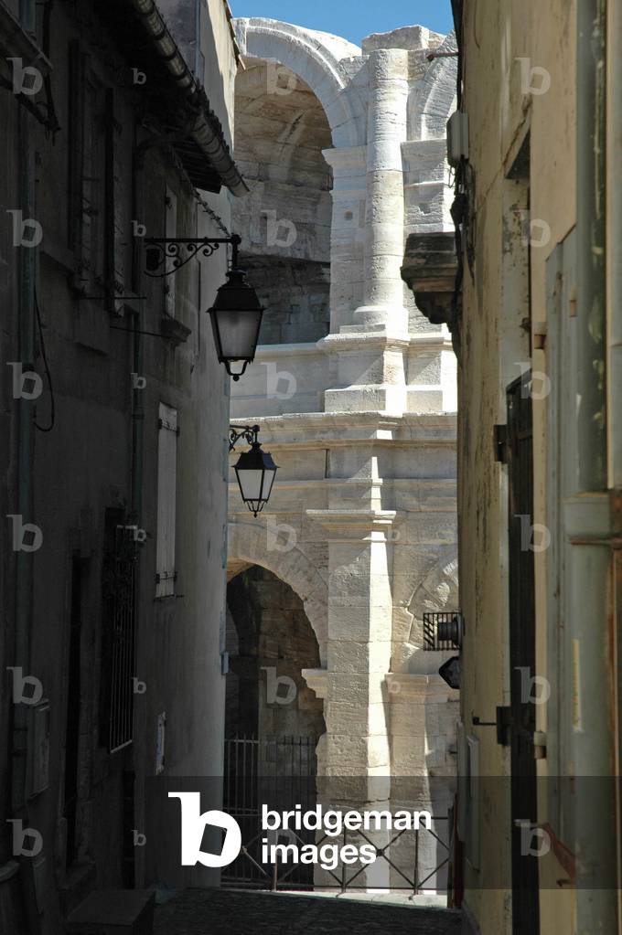 View of the restored part of the arenes d'Arles from an alley of Arles (Bouches du Rhone).