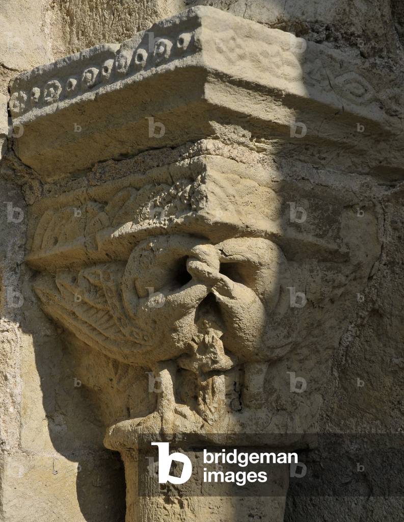 Enlace bird. View of the capital, main portal of the church of Saint Genes (12th century) in Chateaumeillant, Cher (18370), France. Photography 2011