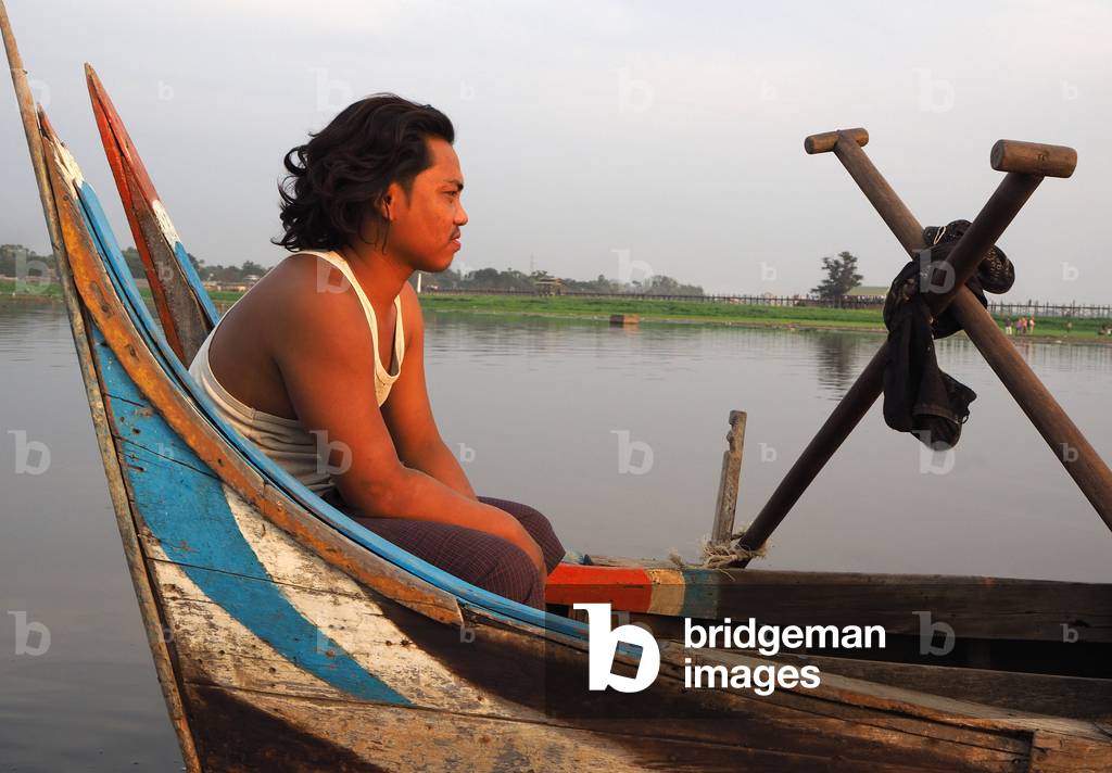 Myanmar - Burma: canoe captain. Teak bridge located on Lake Taungthaman, Amarapura, in central Burma (Mandalay region). It was built from 1849
