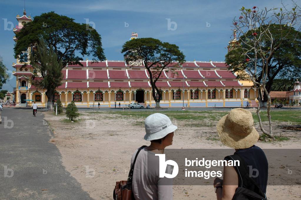 Tourists in front of the Cao Dai Temple. The Caodaism religion installed its seat in Tay Ninh in March 1927 Vietnam 2006