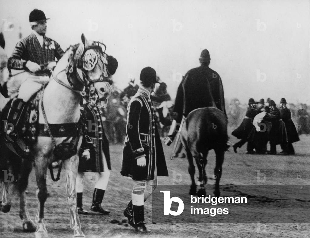 A suffragette attempts to attack the king as he arrives to open parliament, 1908 (b/w photo)