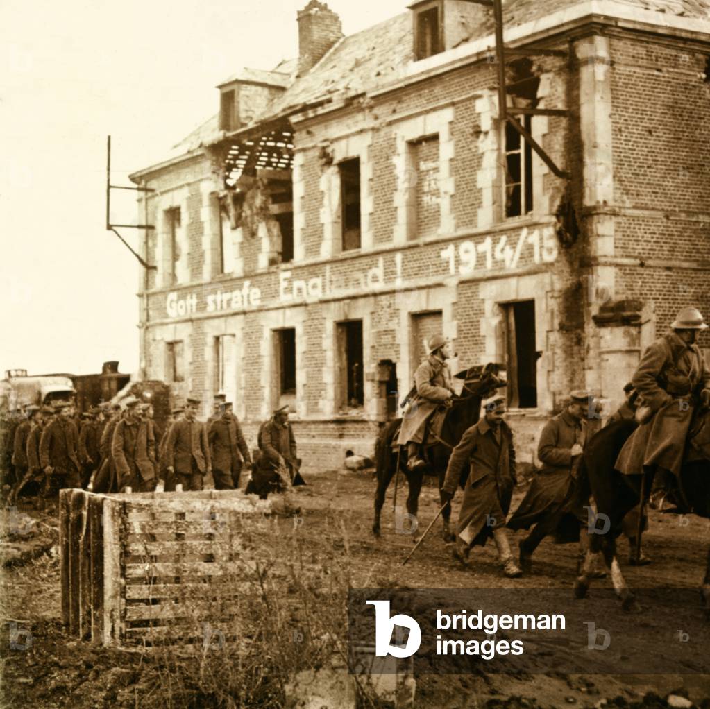 French horsemen in charge of German prisoners (“Gott strafe england” inscribed on the ruined house), First World War (stereoscopic glass plate)