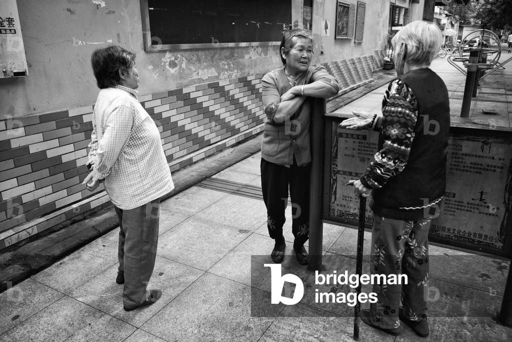 Women talk by street gym and do their excercises Chengdu, China (b/w photo)
