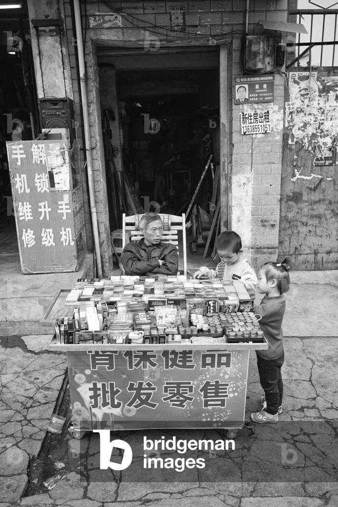 Kids at street stall, Yibin, China (b/w photo)