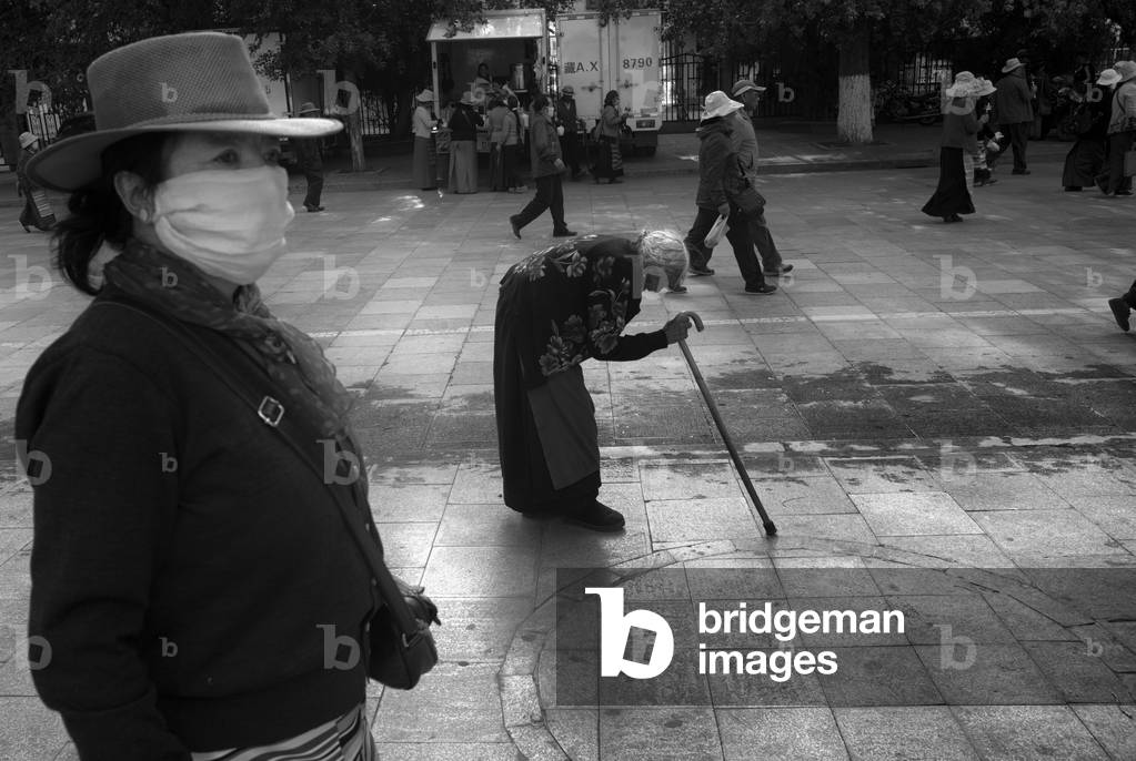 Elderly women making her pilgrimage, Lhasa, Tibet (b/w photo)