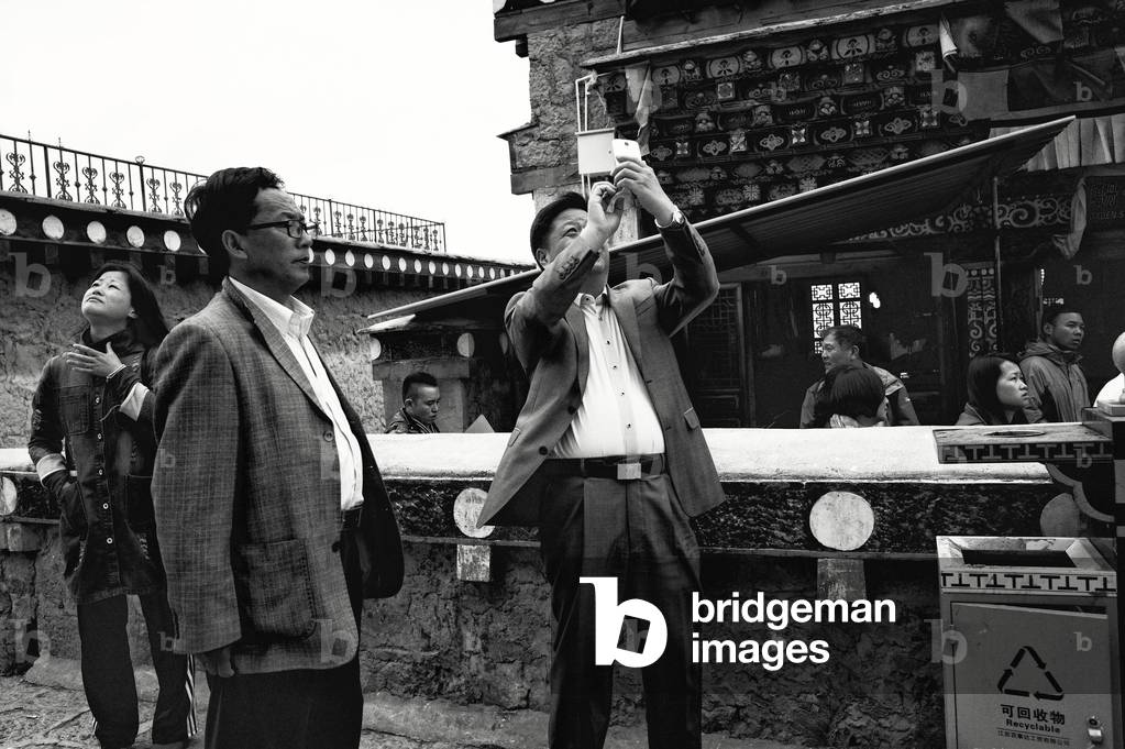 Tourists inside the Shangri la monastery, Yunnan, China (b/w photo)