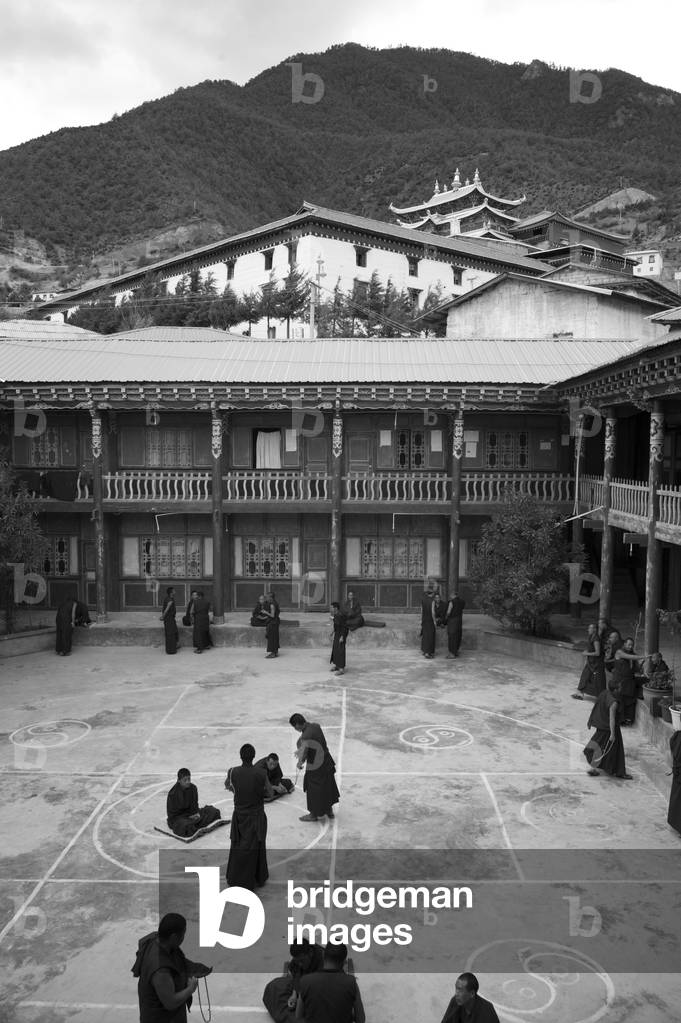 Monks gather for heated discussion/prayer. Yunnan, China (b/w photo)
