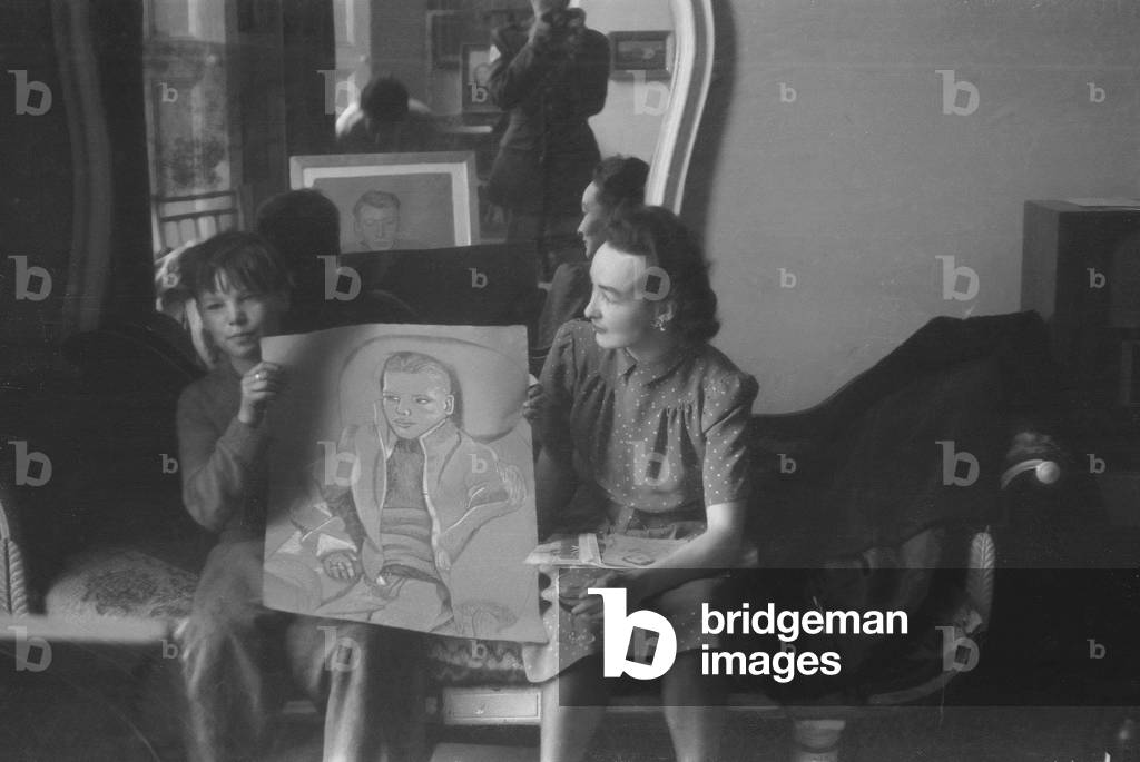 Honour Stern and boy holding up a drawing by Lucian Freud, London, August 1945 (b/w photo)