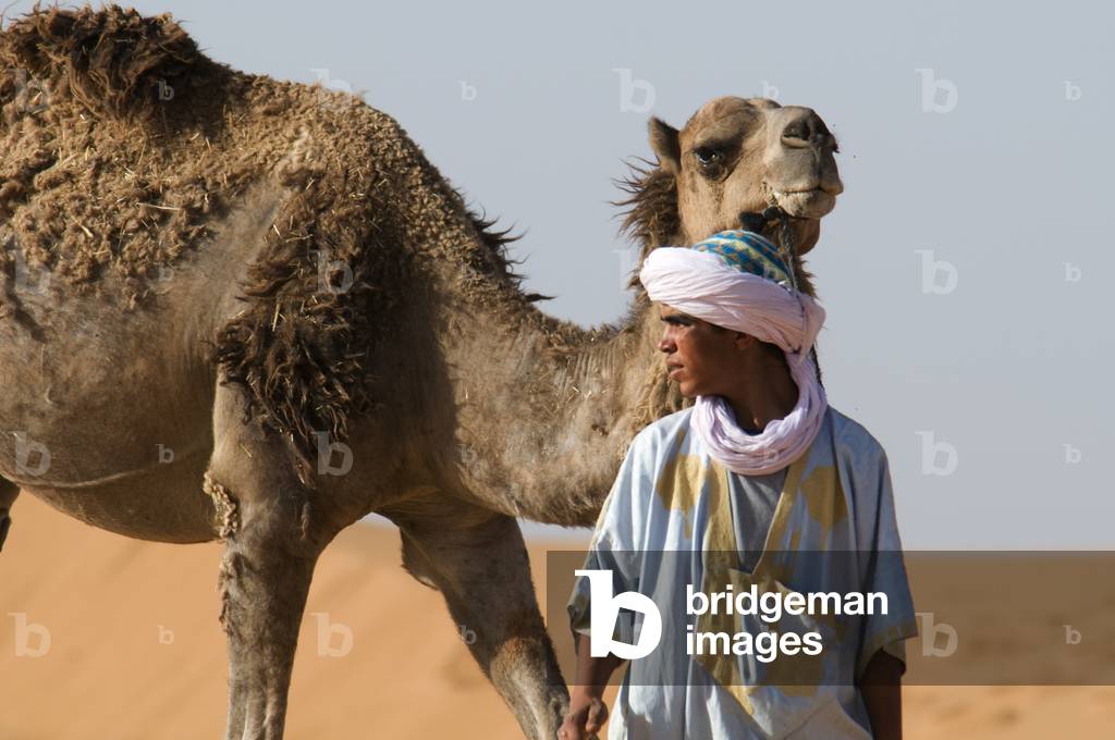 Man with his camel in sand dunes, Erg Chebbi, Merzouga, Morocco (photo)