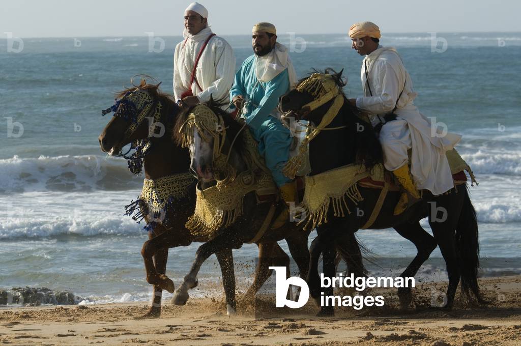 Fantasia horsemen practising on the beach near Safi, Morocco (photo)