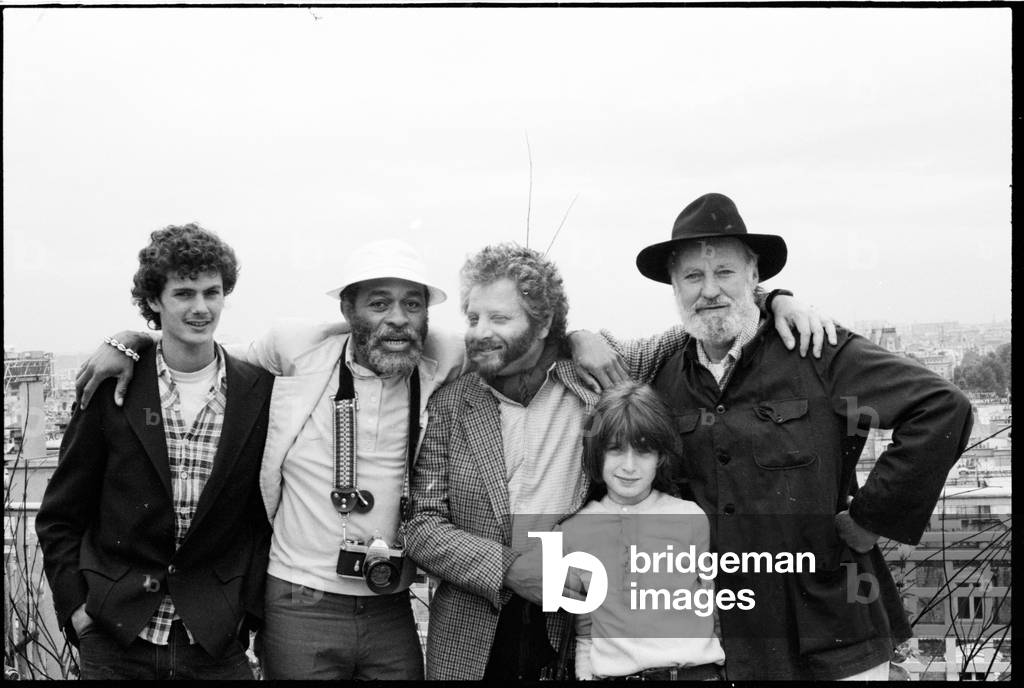 Lawrence Ferlinghetti with friends at Samaritaine, Paris, France,  1980 (b/w photo)
