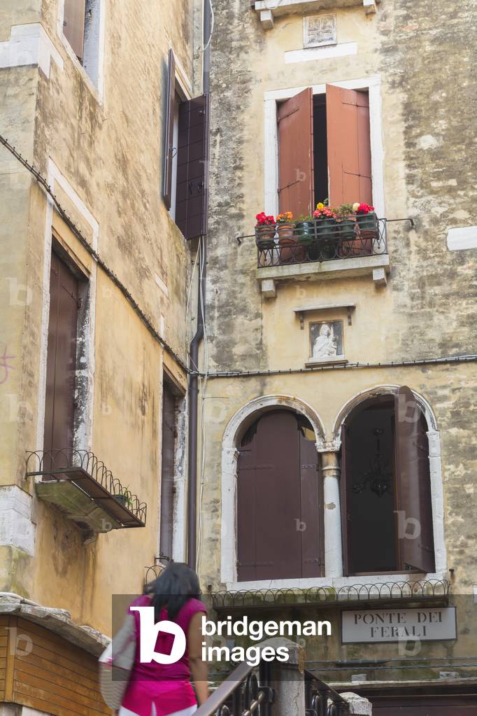 Woman crossing bridge, Venice, Italy (photo)