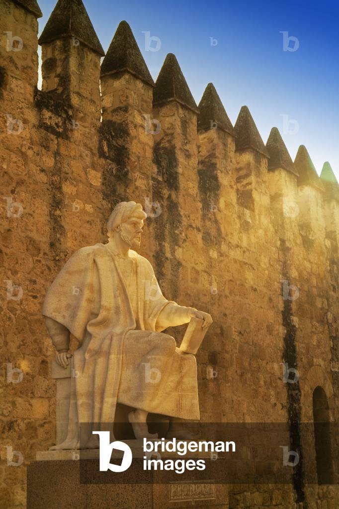 Cordoba, Cordoba Province, Andalusia, southern Spain. Statue of Averroes, Muslim polymath born in Cordoba 1126, died Marrakech, Morocco,1198.  City walls behind.