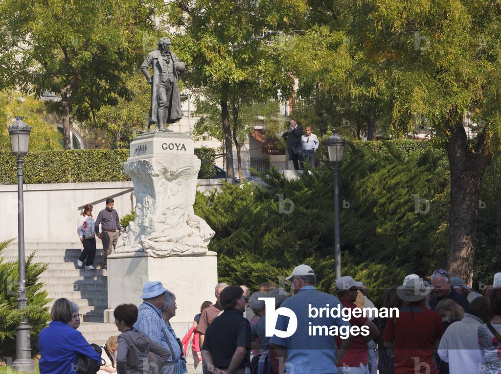 Statue of Spanish artist Francisco Goya outside El Prado Museum overlooking queue of visitors waiting to gain entrance to the gallery, Madrid, Spain
