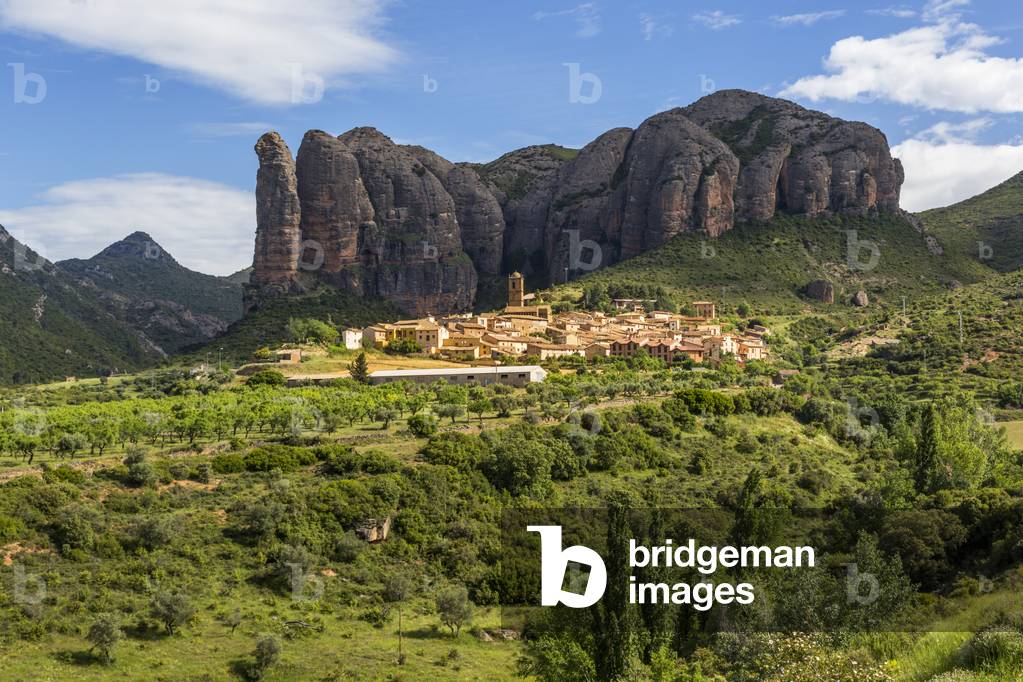 Village of Agüero beneath the conglomerate rock formations of the Mallos de Riglos, Huesca Province, Aragon, Spain. The Mallos de Riglos are approximately 300 meters high.  The area is popular with climbers. (photo)