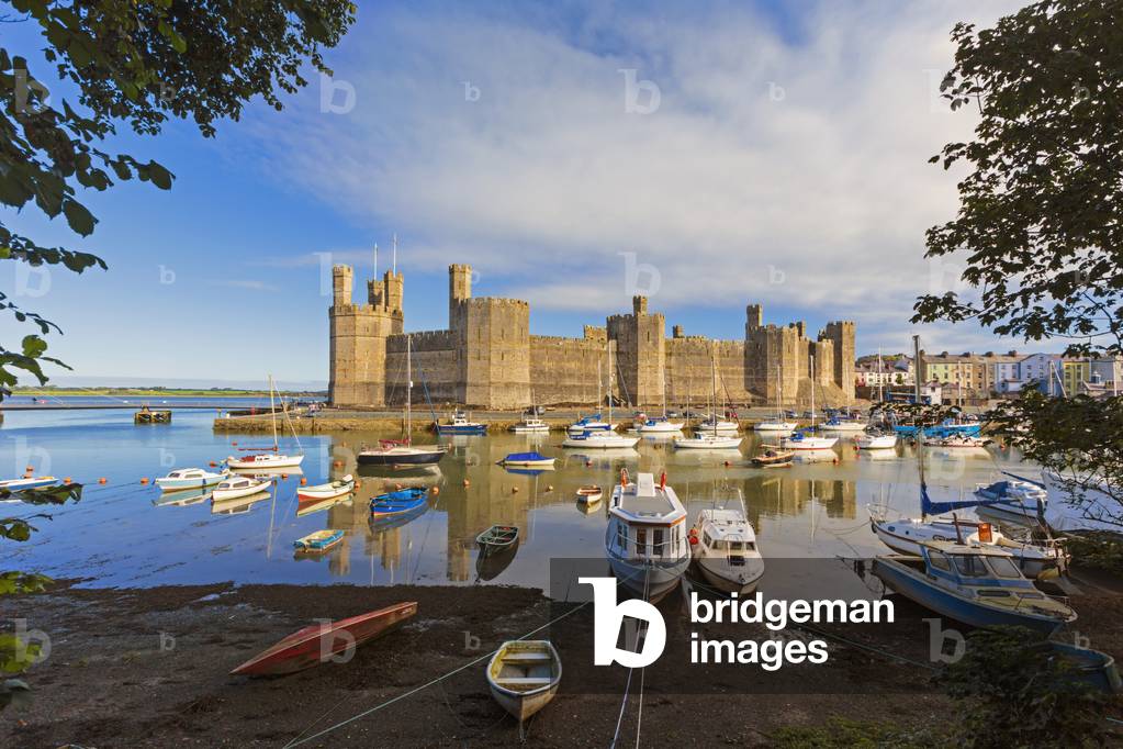 Caernarfon or Carnarvon or Caernarvon, Gwynedd, Wales, United Kingdom.  Caernarfon Castle seen across the River Seiont.  It is part of the UNESCO World Heritage Site which includes a group of Castles and Town Walls of King Edward in Gwynedd.  Harlech and Beaumaris castles and the castle and fortified complex of Conwy are the other sites in the group.