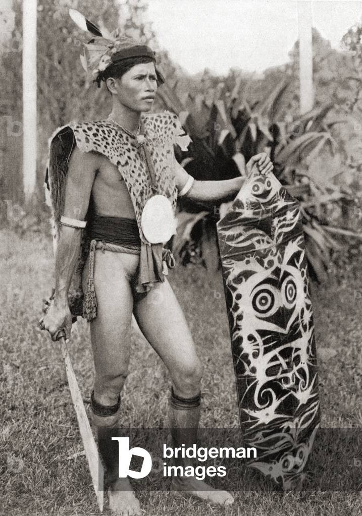A native of Borneo in war costume, from 'Customs of The World', publ. c.1913 (b/w photo)