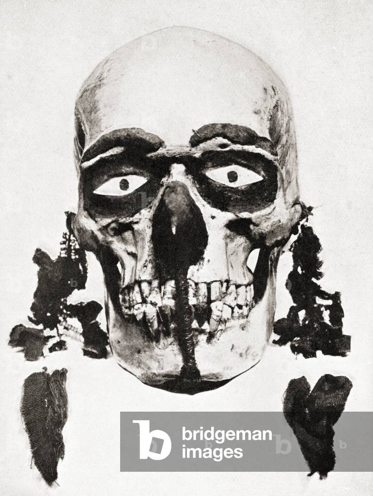 A skull preserved and decorated and used for divination on the Torres Straits Islands, Papua New Guinea, Melanesia.  The inquirer would clean, paint and anoint the skull, enjoin it to speak the truth, put it near his head at night, go to sleep and dream and his actions would be based on the dream.  From a nineteenth century photograph in From Customs of The World, published c.1913.
