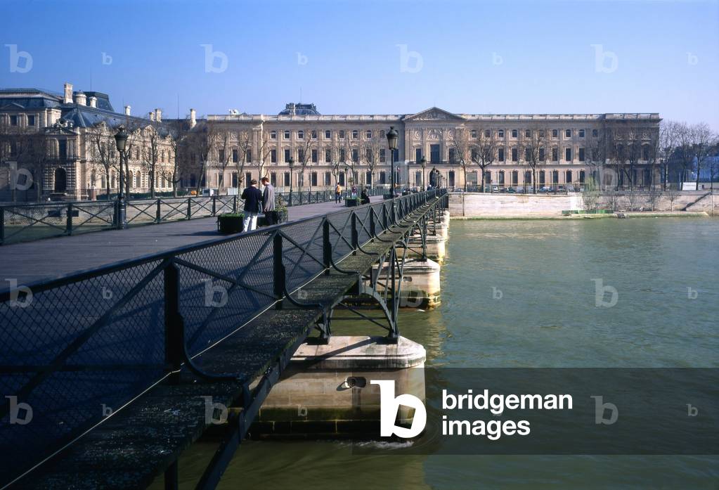 The Louvre since the Pont des Arts (1801-1984), Paris 75001. Reconstruction by Louis Arretche. The Passerelle des Arts, the first iron bridge in Paris, had the mission of joining the Institut de France and the Louvre - which was then called the Palais des Arts. Reserved for pawns, it was built from 1801 to 1804. It initially consisted of nine arches. Following numerous river accidents, its reconstruction was decided in 1981 but two arches were removed to line them up on the Pont Neuf.