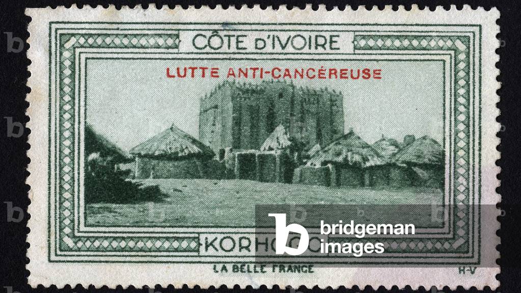 View of the traditional city of Khorogo (Ivory Coast), with the palace of the chefs - Illuminated vignette, with mention of anti-cancer struggle - claim for the Ivory Coast, La Belle France, 20th century