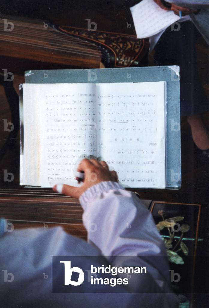 Chinese girl playing gu qin using, Chinese musical notation in Shanghai music school