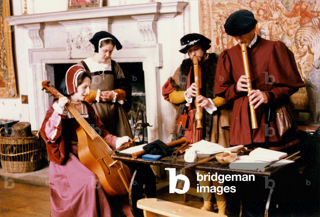 Renaissance singers and players with viol and recorder, singing around atable with musical parts on it