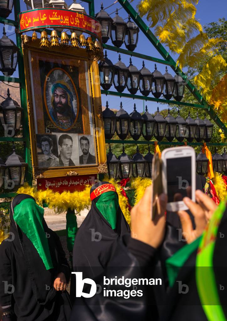Woman Taking Pictures with a Mobile Phone of Shiite Muslim Women mourning Imam Hussein on the Day of Tasua, Lorestan Province, Khorramabad, Iran (photo)