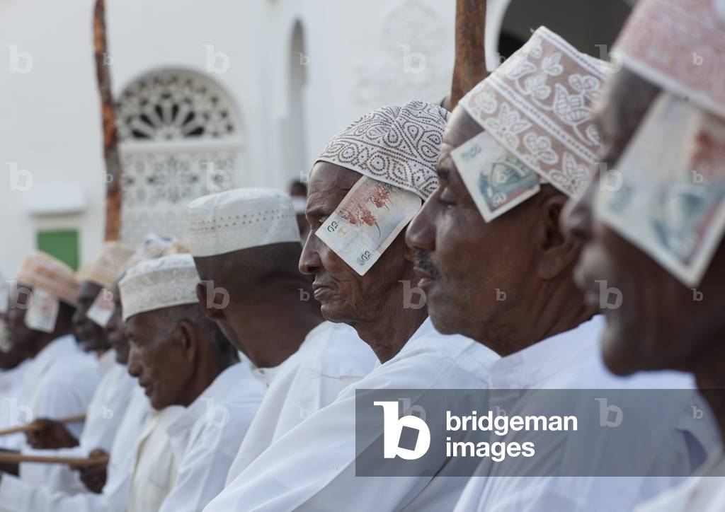 Men in a row with banknotes in kofia hat, Maulidi festival, Lamu Kenya, Africa (photo)