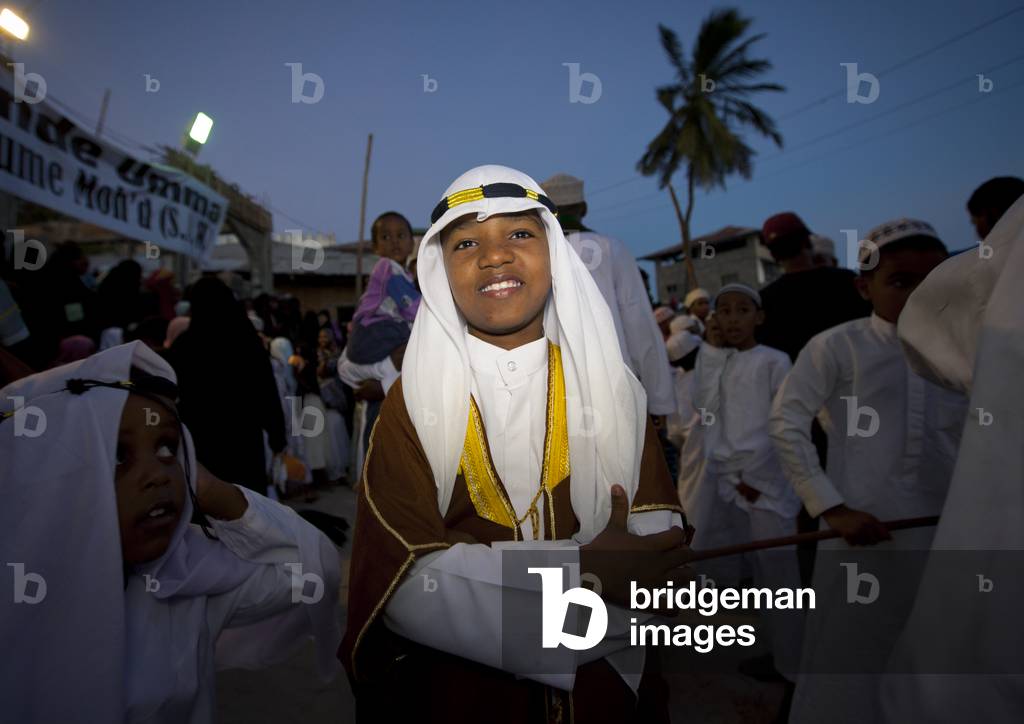 Young boy in traditional dressing among crowd during maulidi festival celebration, Lamu, Kenya, Africa

 (photo)