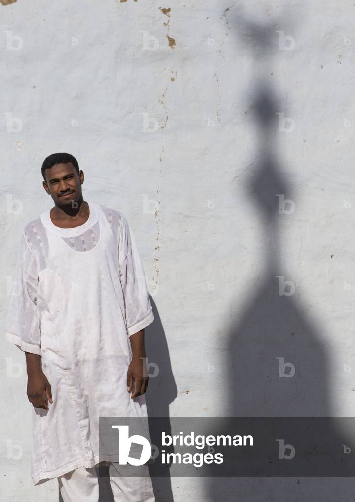 Nubian Man Standing in Front of a Wall with a Minaret Shadow, Tumbus, Nubia, Sudan (photo)