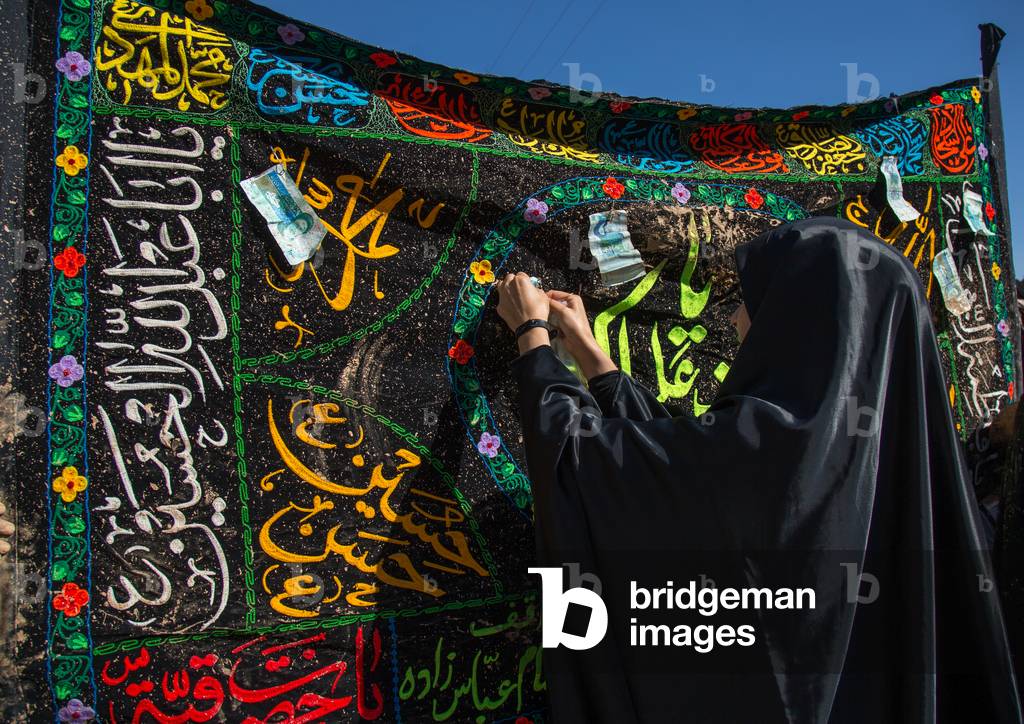 Iranian Shiite Muslim Women Covered in Mud Attaching Bank Notes on a Flag during Ashura, Kurdistan Province, Bijar, Iran (photo)