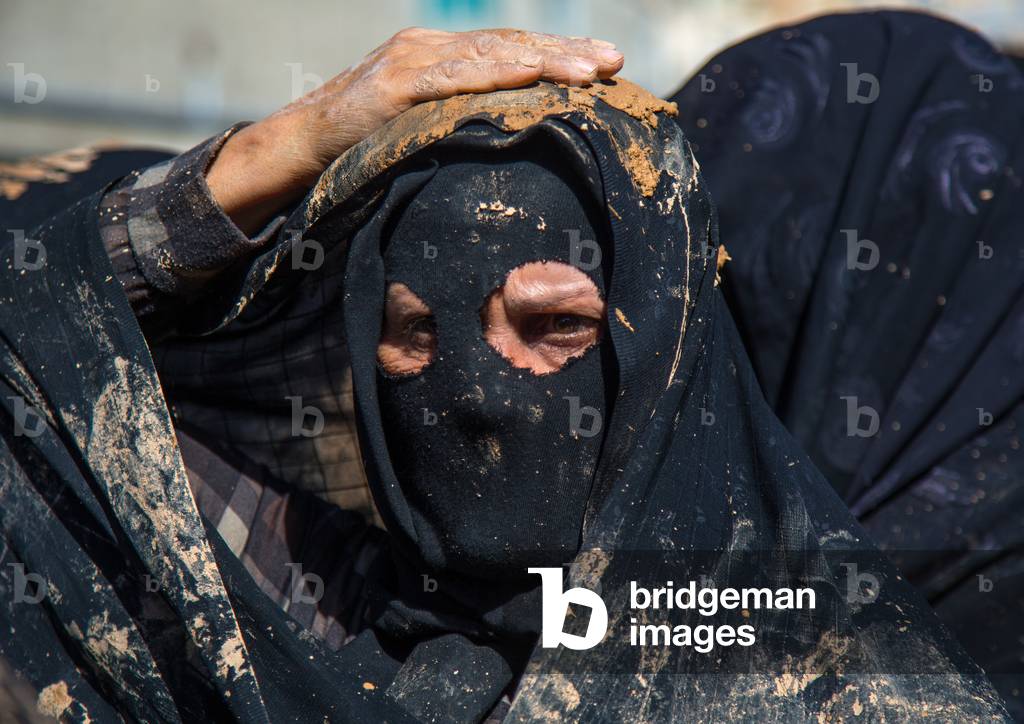 Iranian Shiite Muslim Woman Covered in Mud, Chanting and Self-flagellating during Ashura, Kurdistan Province, Bijar, Iran (photo)