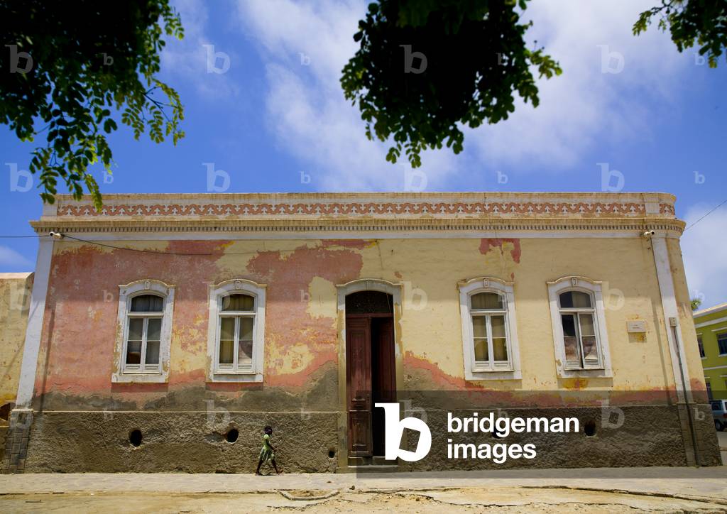 Girl Passing By a Colonial building in Namibe Town, Angola, Africa (photo)