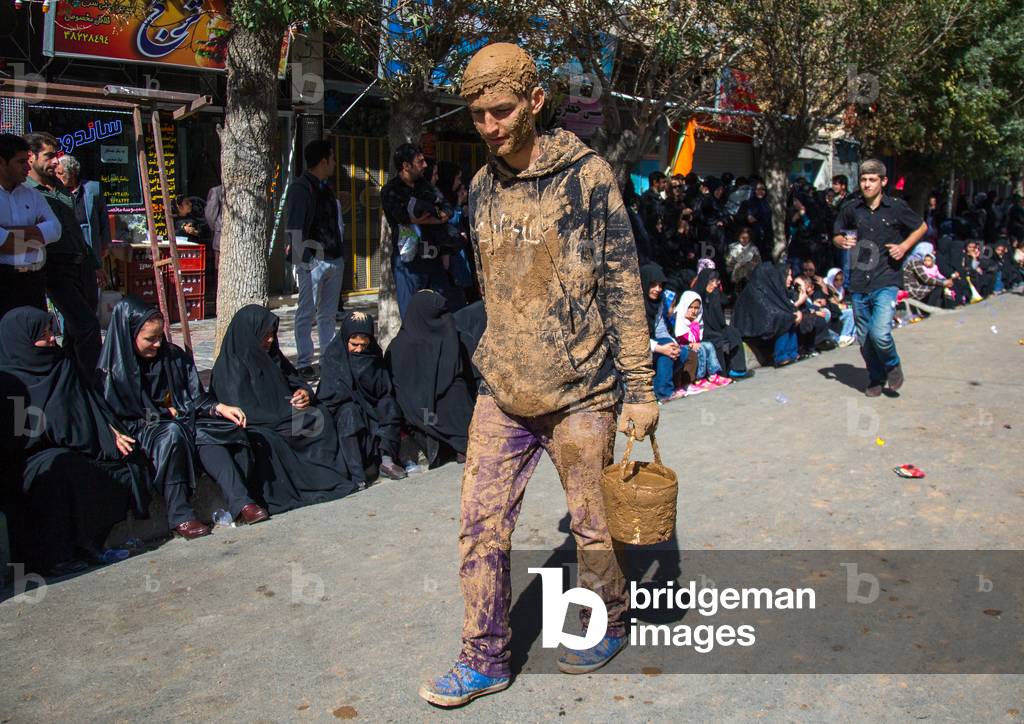 Iranian Shiite Muslim Man Covered in Mud with a Bucket during Ashura Day, Kurdistan Province, Bijar, Iran (photo)