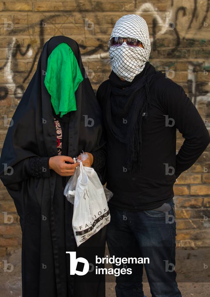Iranian Shiite Muslim Couple mourning Imam Hussein on the Day of Tasua with their Faces Covered by a Veil, Lorestan Province, Khorramabad, Iran (photo)