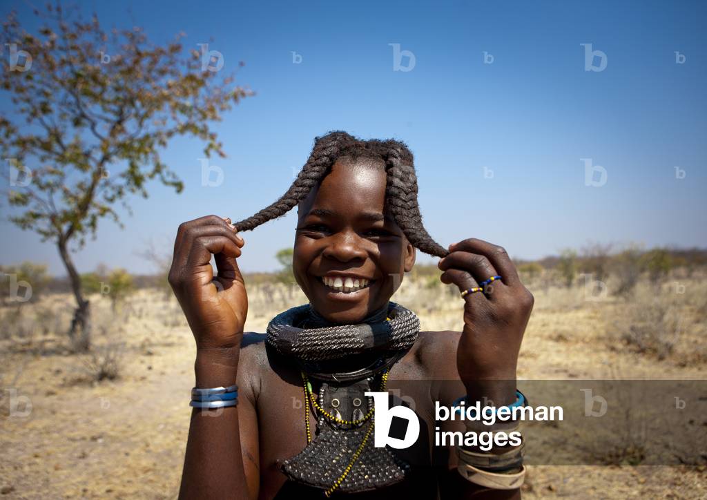 Himba Girl called Kamundomba holding her Two Plaits, Village of Habu Haru, Angola, Africa (photo)