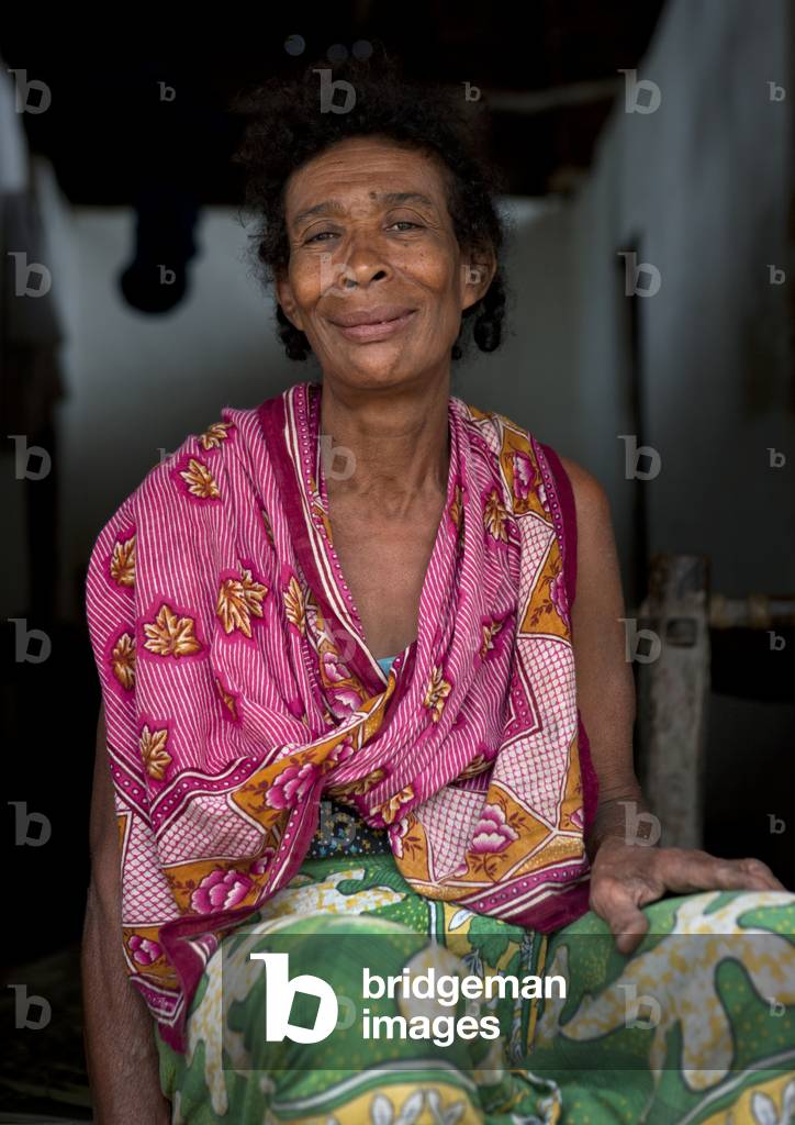 Woman with colorful dressing sitting in her house, Siyu, Pate island, Lamu, Kenya, Africa (photo)