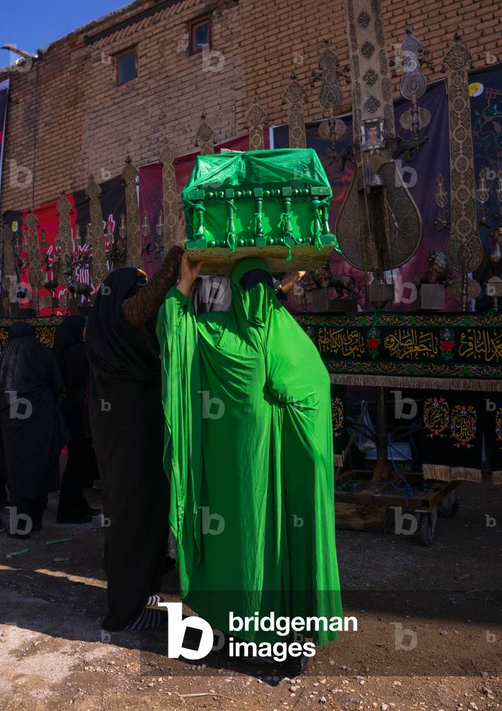 Iranian Shiite Muslim Woman on the Day of Tasua with her Face Covered by a Green Veil and Collecting Money in a Craddle, Lorestan Province, Khorramabad, Iran (photo)