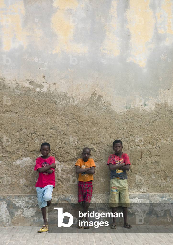 Three Boys Leaning on a Wall, Benguela, Angola, Africa (photo)