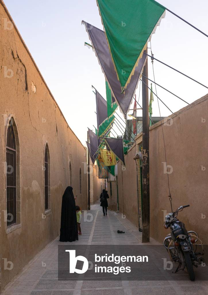 Muslim Women in a Narrow Street with Green Flags, Yazd Province, Yazd, Iran (photo)
