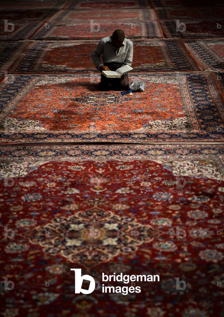 Iranian Shiite Muslim Man Reading the Koran in Fatima Al-masumeh Mosque, Fars Province, Shiraz, Iran (photo)